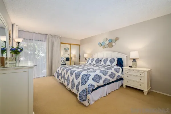 a spacious bedroom with a bed and a chandelier