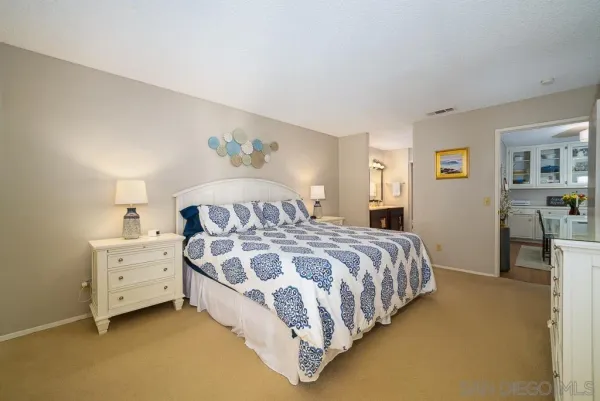 a spacious bedroom with a bed and a cabinets