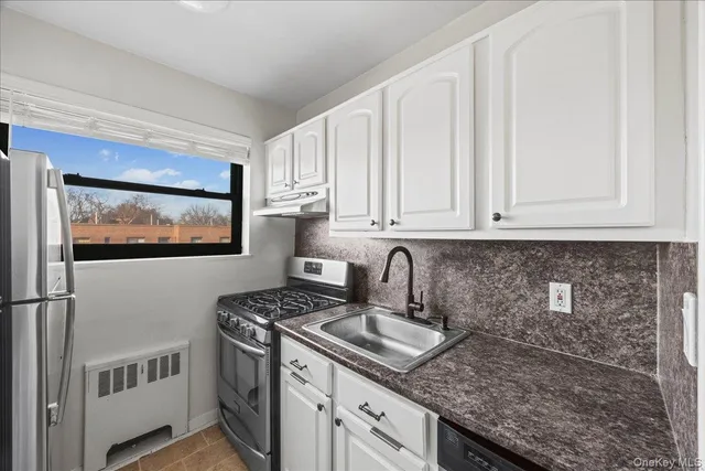 a kitchen with stainless steel appliances granite countertop a sink stove and cabinets