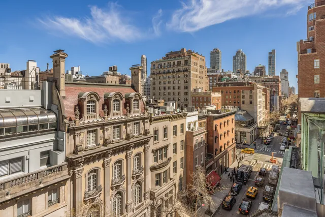 a roof deck with couches and potted plants