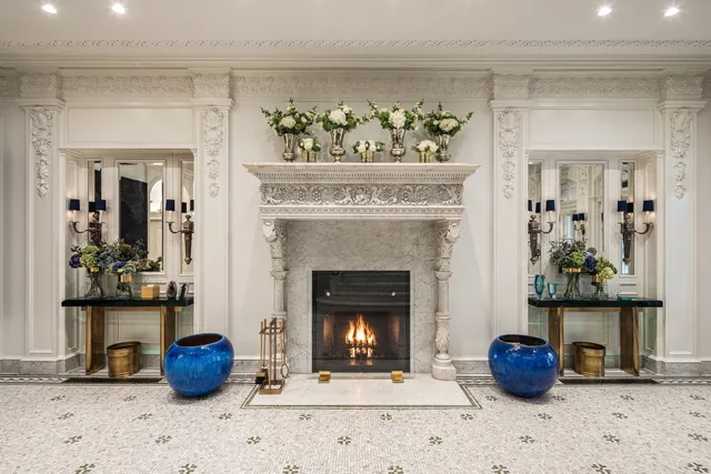 a view of a hallway with a fireplace and a chandelier