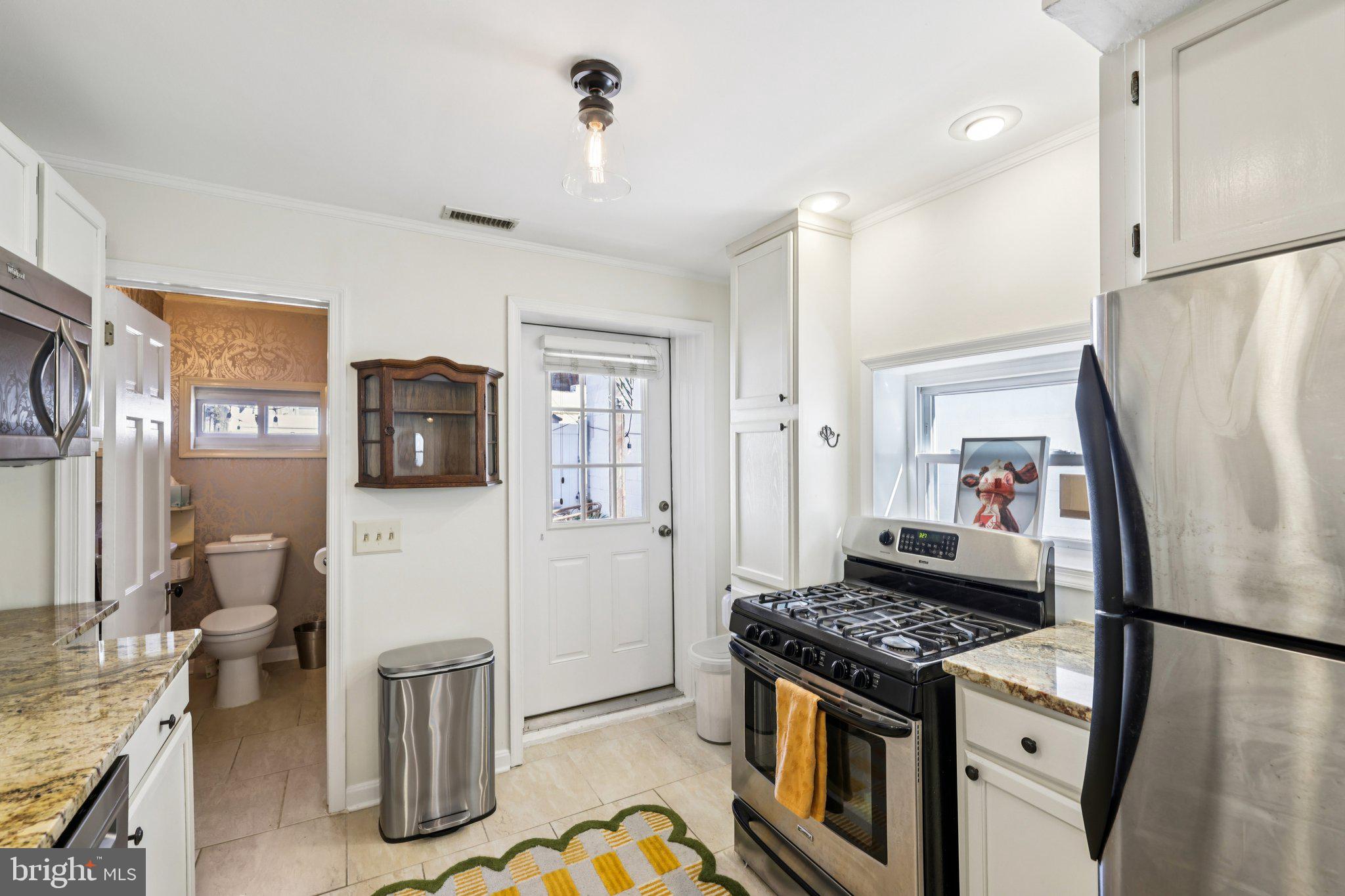 617 South Durham Street Baltimore, MD 21231 - Photo 11 of 42 a kitchen with stainless steel appliances granite countertop a refrigerator a stove and a sink