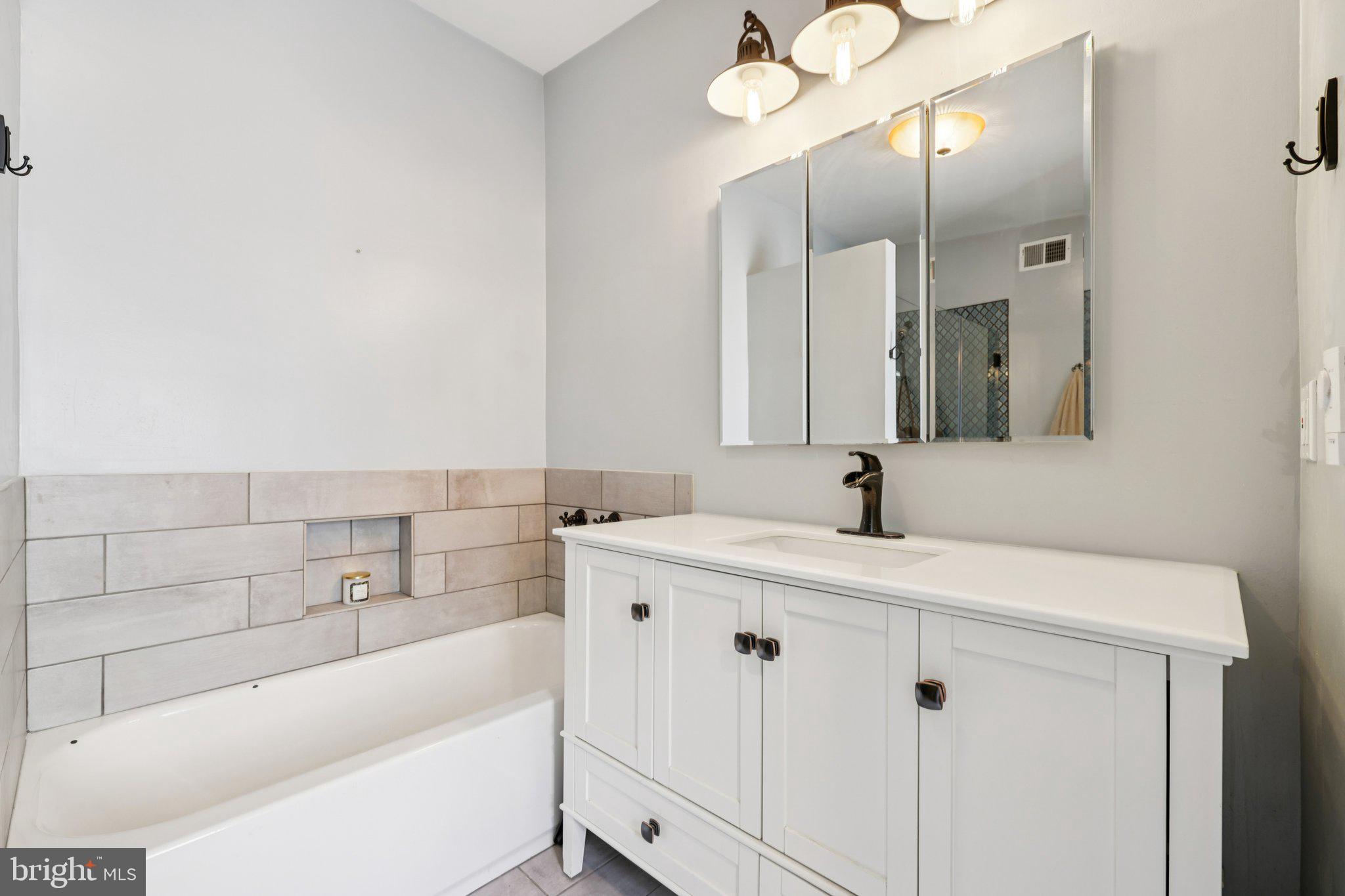 617 South Durham Street Baltimore, MD 21231 - Photo 17 of 42 a bathroom with a tub sink and mirror