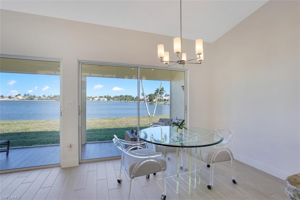 7311 Mill Pond Circle Naples, FL 34109 - Photo 11 of 22 a dining room with furniture a chandelier and wooden floor