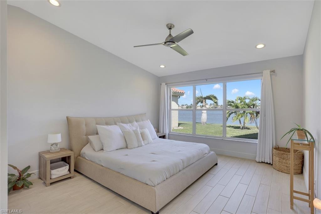 7311 Mill Pond Circle Naples, FL 34109 - Photo 13 of 22 a bedroom with a bed and a large window