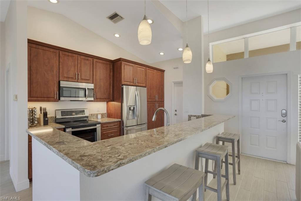 7311 Mill Pond Circle Naples, FL 34109 - Photo 4 of 22 a kitchen with granite countertop a sink cabinets and stainless steel appliances