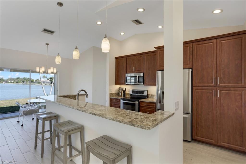 7311 Mill Pond Circle Naples, FL 34109 - Photo 5 of 22 a kitchen with granite countertop a refrigerator and a sink