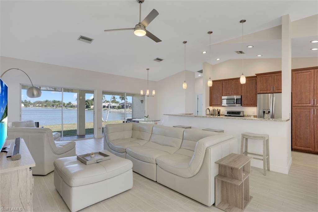 7311 Mill Pond Circle Naples, FL 34109 - Photo 6 of 22 a view of living room kitchen with stainless steel appliances kitchen island furniture and a large window