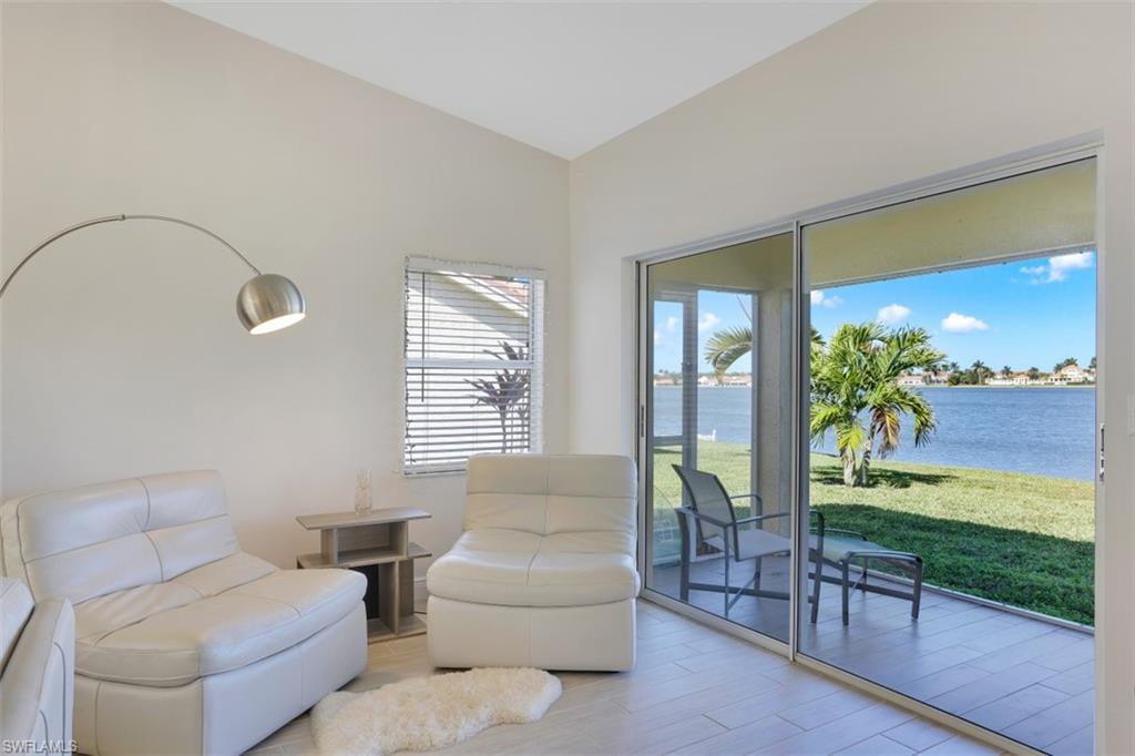 7311 Mill Pond Circle Naples, FL 34109 - Photo 8 of 22 a living room with furniture and a floor to ceiling window