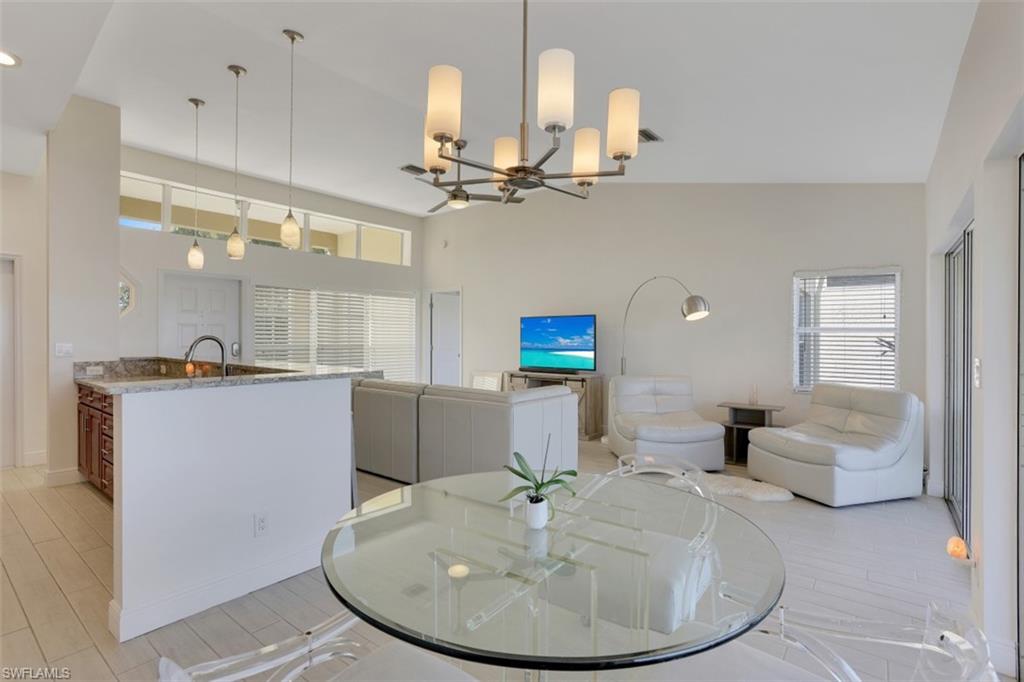 7311 Mill Pond Circle Naples, FL 34109 - Photo 10 of 22 a very nice looking dining room with a table and chandelier