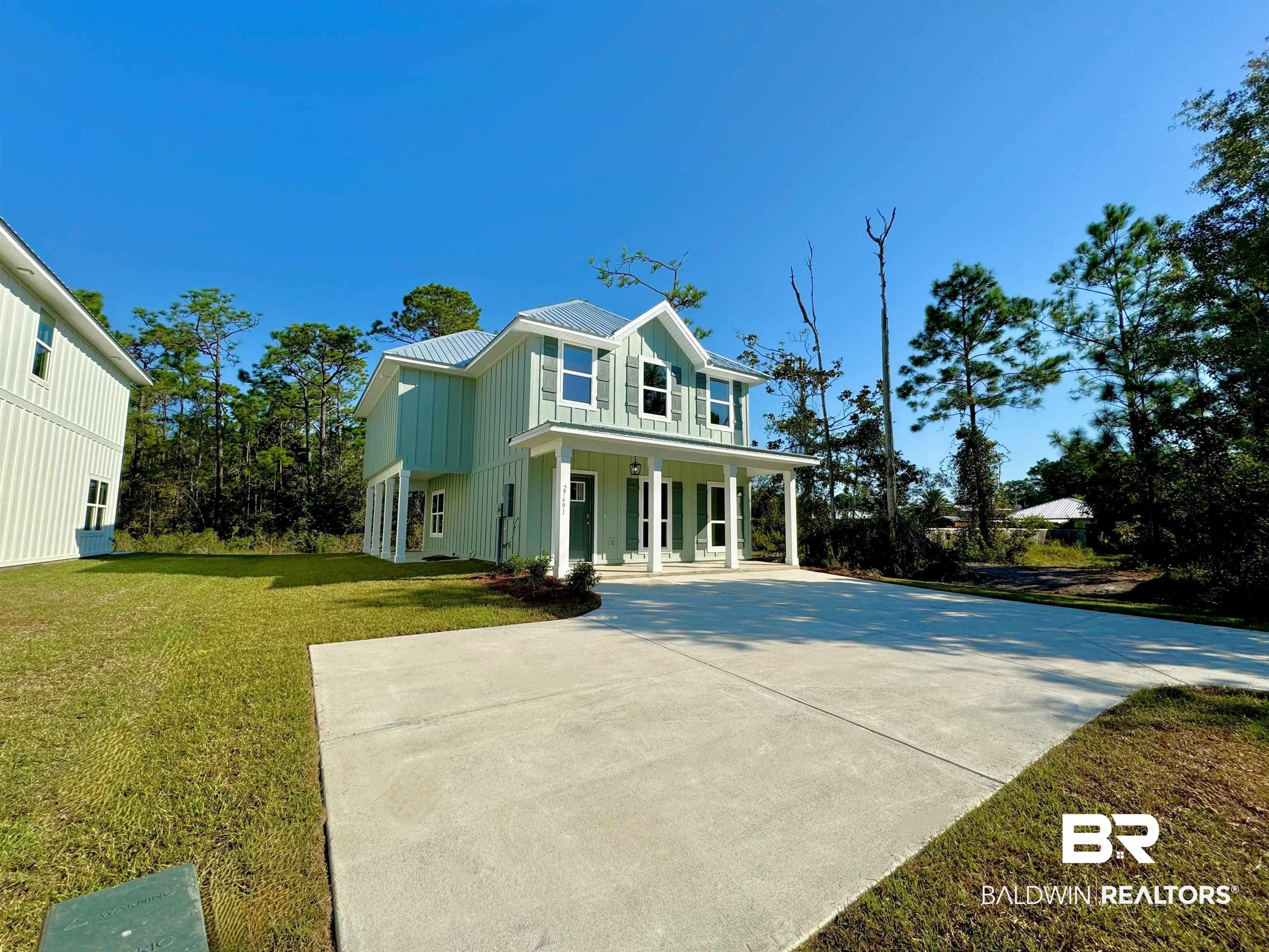 27491 Canal Road Orange Beach, AL 36561 - Photo 4 of 20 View of side of property with a lawn and covered porch