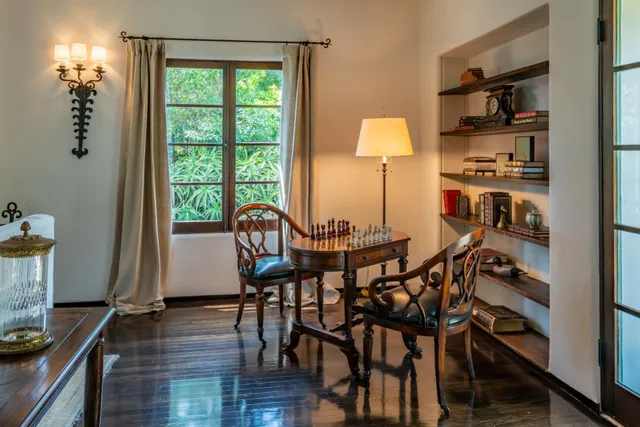 a large white kitchen with stainless steel appliances wooden floor and a large window