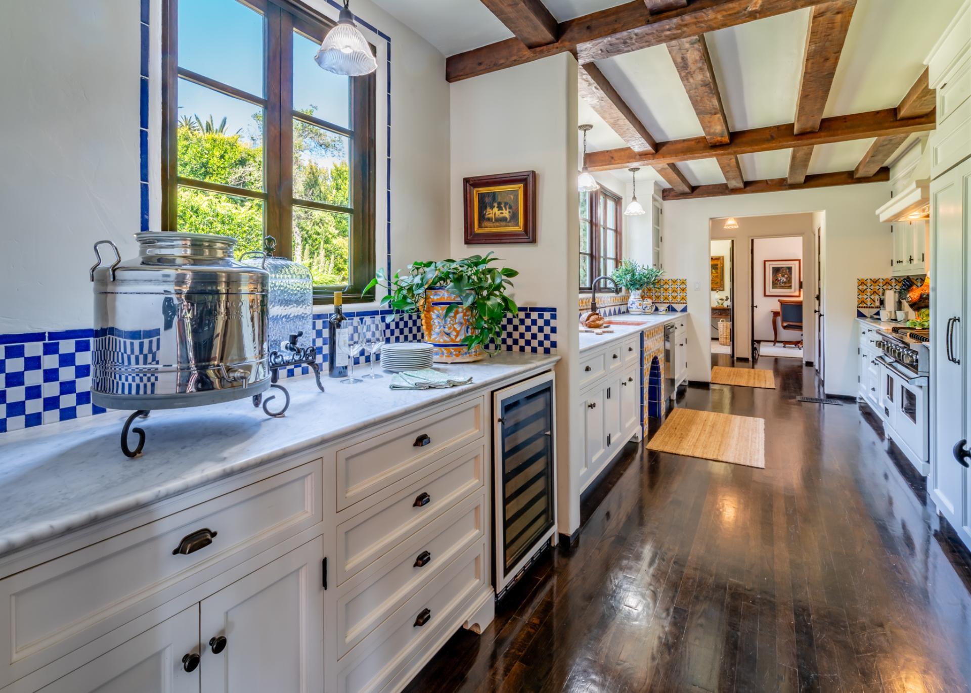1098 Golf Road Montecito, CA 93108 - Photo 16 of 62 a large white kitchen with stainless steel appliances wooden floor and a large window