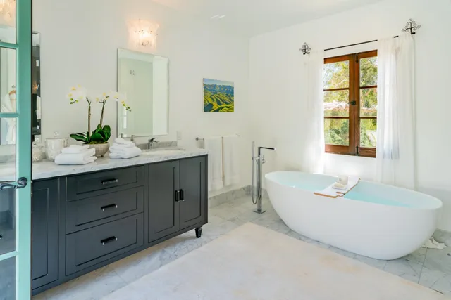 a living room with furniture a flat screen tv and a floor to ceiling window
