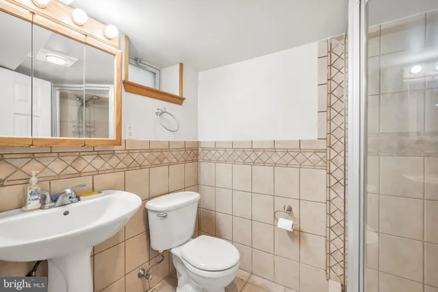 a bathroom with a toilet sink and mirror
