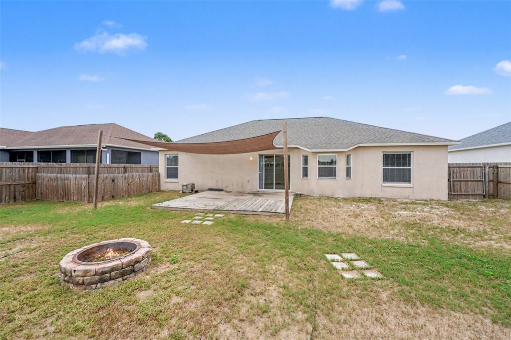 865 Terranova Road Winter Haven, FL 33884 - Photo 12 of 12 a backyard of a house with wooden deck and barbeque oven