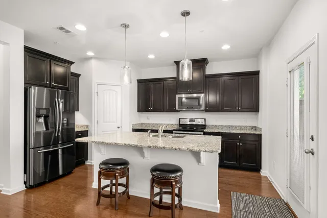 a kitchen with refrigerator a sink and chairs