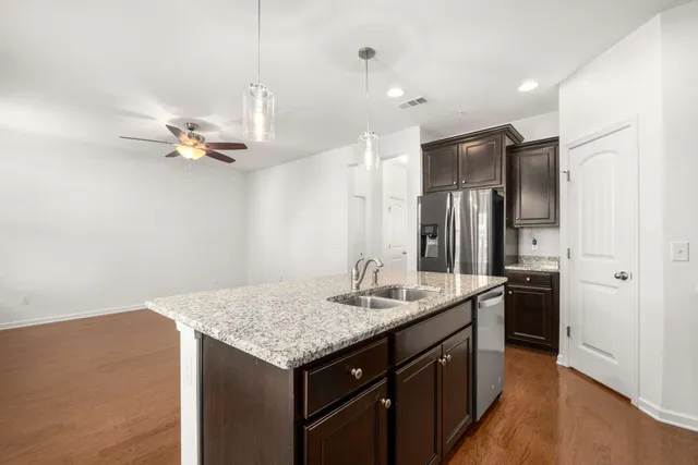 a kitchen with a sink dishwasher a stove and a refrigerator with wooden floor