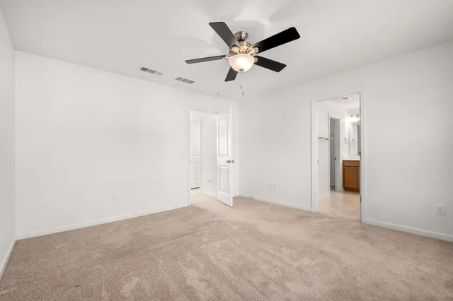 an empty room with ceiling fan and window