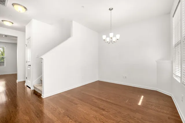 a view of a hallway with wooden floor and chandelier