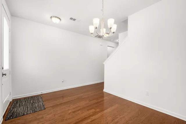 a room with wooden floor and chandelier