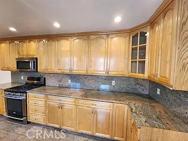 a kitchen with granite countertop a stove a sink and a microwave