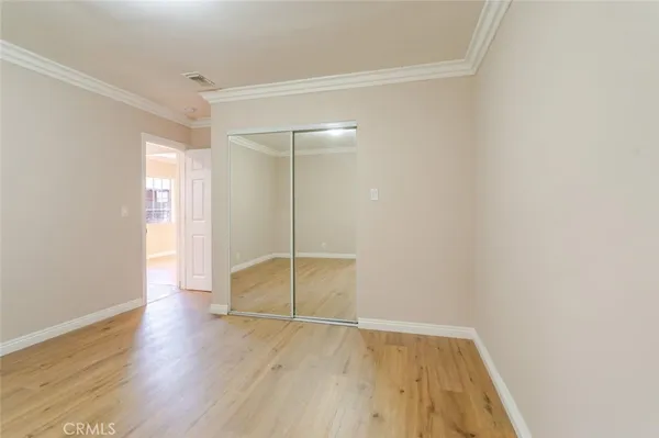 an empty room with wooden floor and door