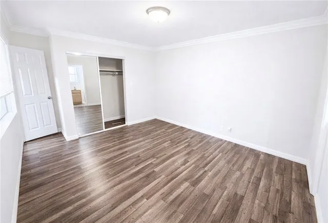 a view of empty room with wooden floor