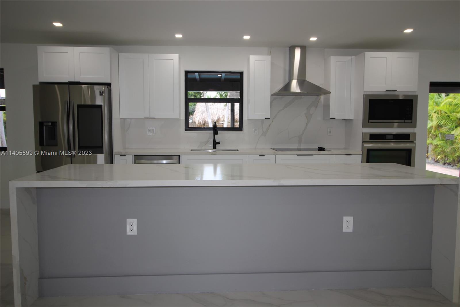 10810 Southwest 28th Street Miami, FL 33165 - Photo 19 of 45 a view with kitchen island a sink a counter space stainless steel appliances and cabinets