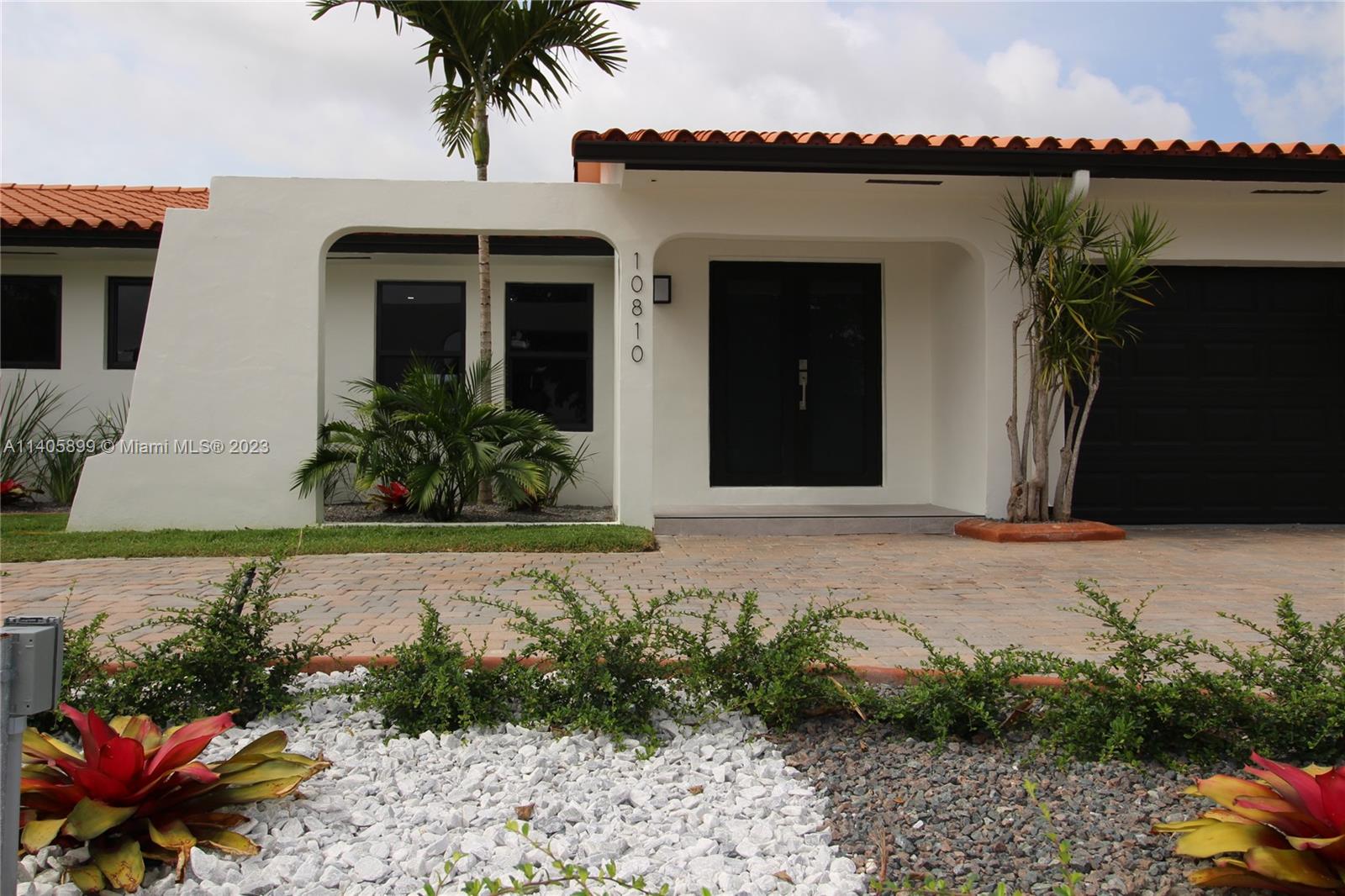 10810 Southwest 28th Street Miami, FL 33165 - Photo 2 of 45 a front view of a house with a garden