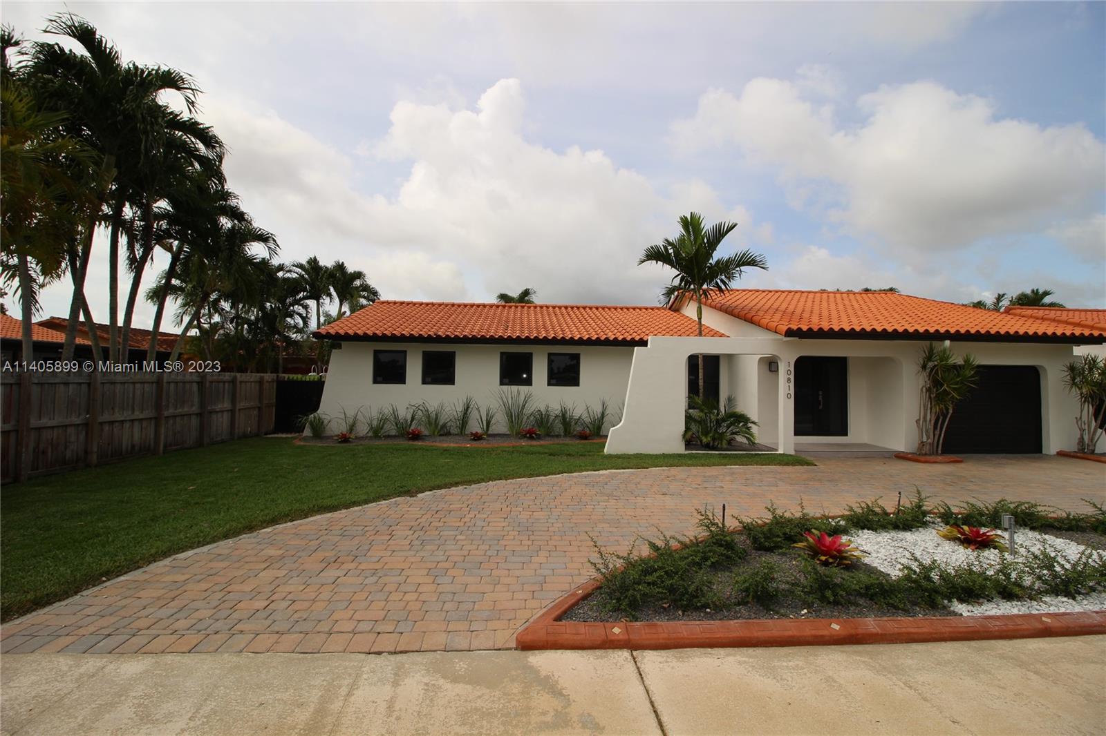 10810 Southwest 28th Street Miami, FL 33165 - Photo 3 of 45 a front view of a house with a garden