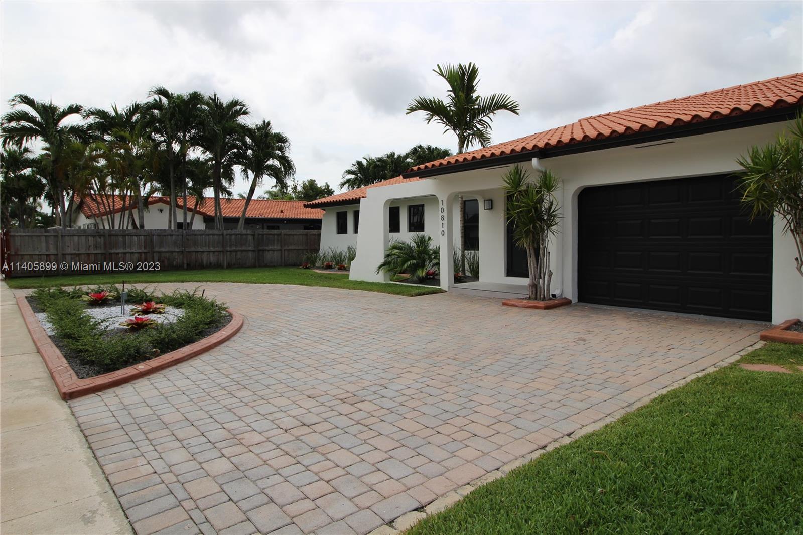 10810 Southwest 28th Street Miami, FL 33165 - Photo 5 of 45 a front view of a house with a garden and potted plants
