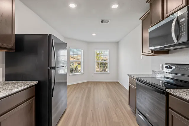 a kitchen with stainless steel appliances granite countertop a refrigerator and a sink