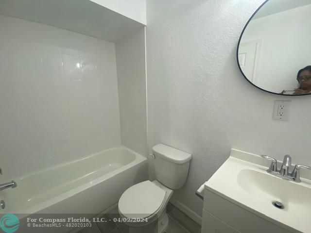 a white toilet sitting next to a bathroom sink and tub