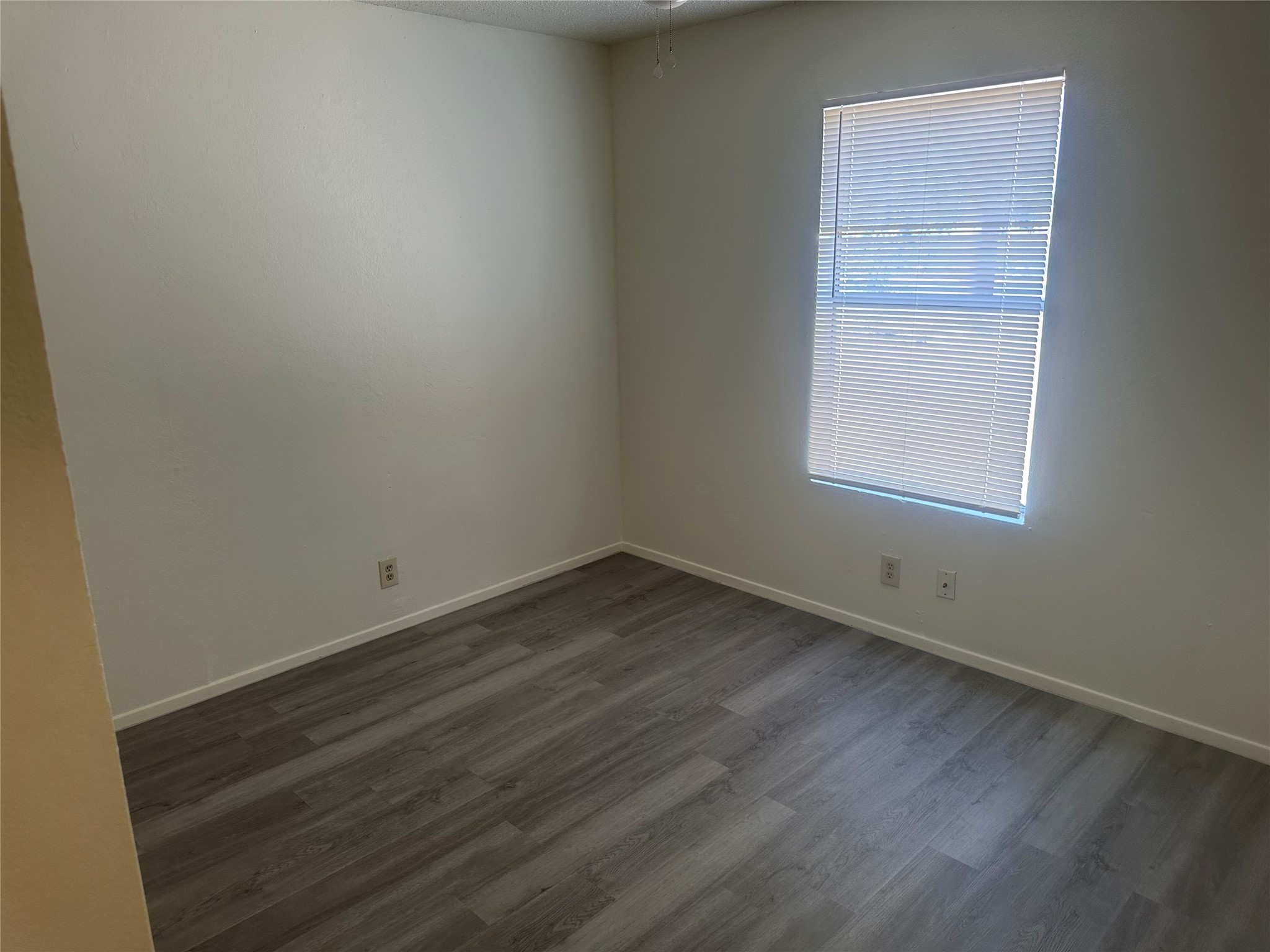 2602 South Bagdad Road, Unit B Leander, TX 78641 - Photo 17 of 23 Smooth wood-look flooring and a single window define this versatile bedroom space.