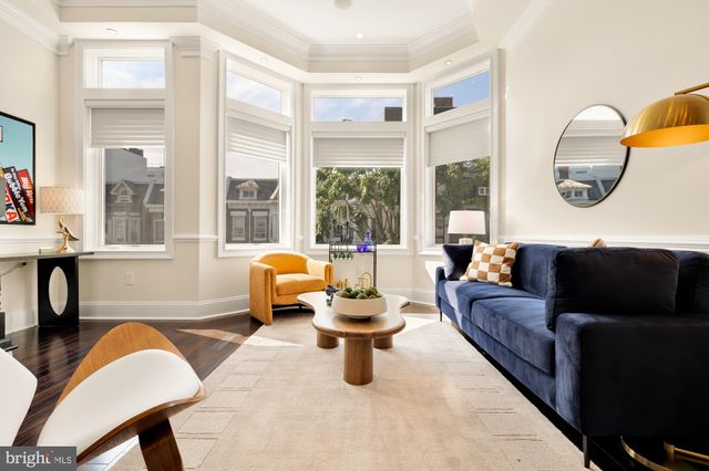 a living room with fireplace furniture and a large window