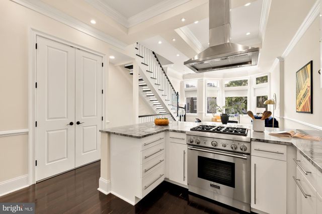 a kitchen with a stove and white cabinets