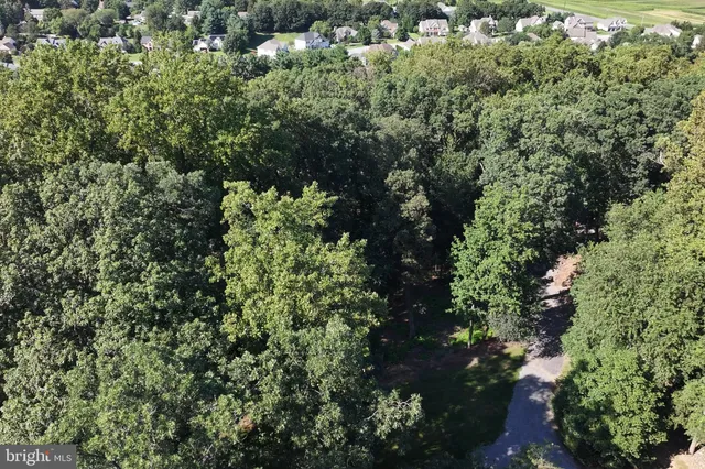 an aerial view of a house with a lush green forest