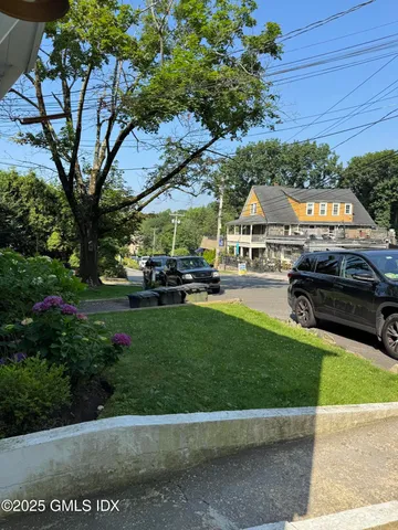 a front view of a house with a garden and trees