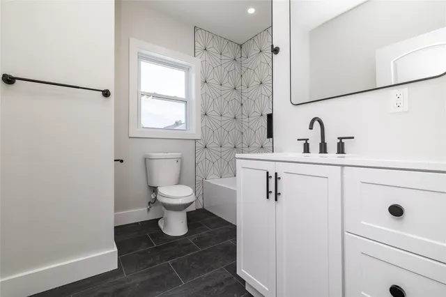 a bathroom with a sink toilet a mirror and shower