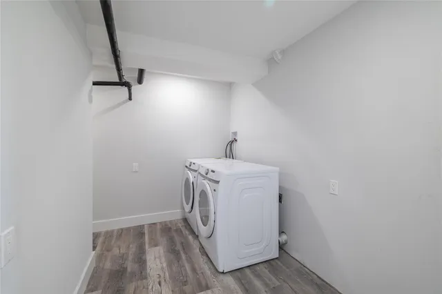 a utility room with wooden floor washer and dryer
