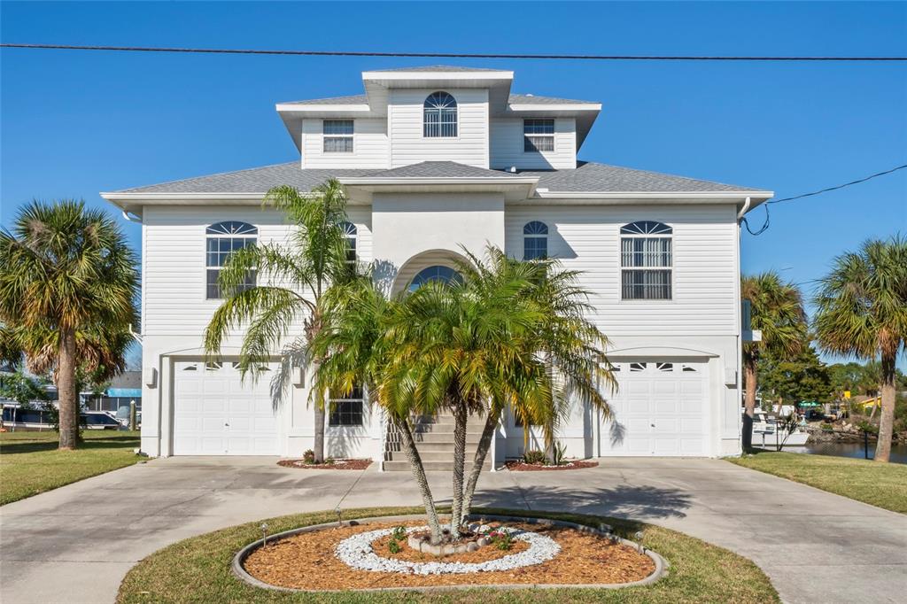 3459 Flamingo Boulevard Hernando Beach, FL 34607 - Photo 4 of 94 a front view of a house with a yard