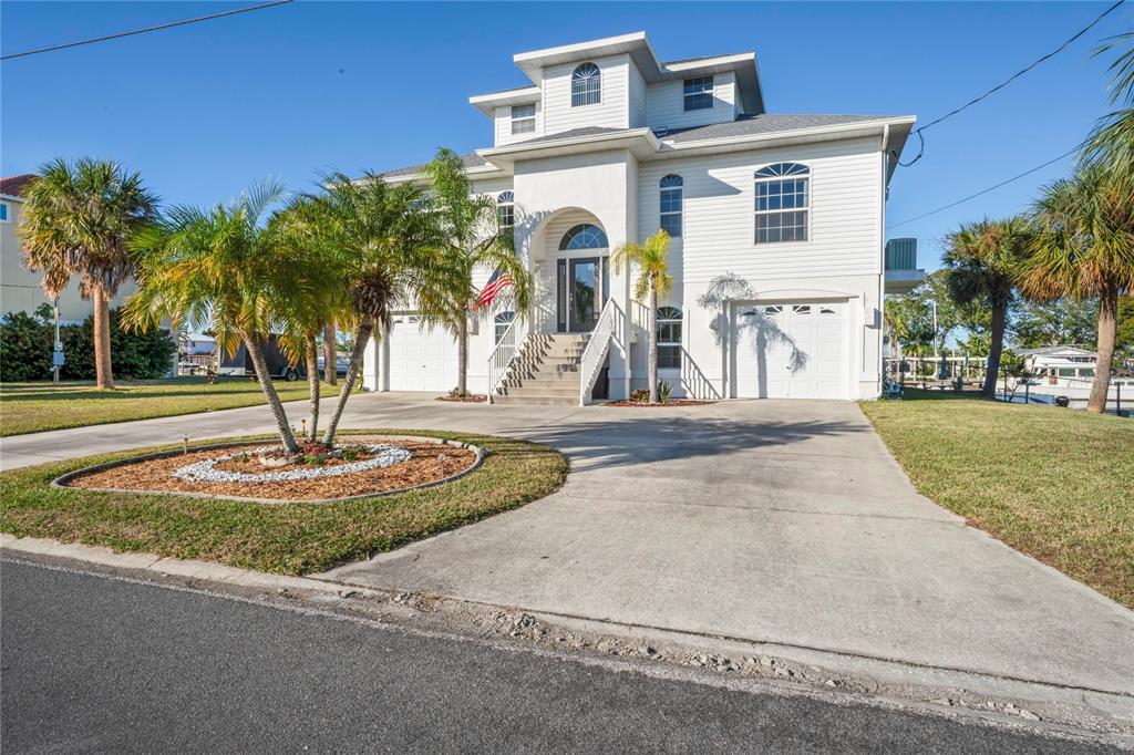 3459 Flamingo Boulevard Hernando Beach, FL 34607 - Photo 91 of 94 a front view of a house with garden and trees