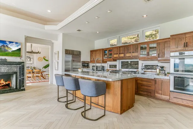 a kitchen with stainless steel appliances granite countertop a stove a sink dishwasher and a refrigerator with wooden floor