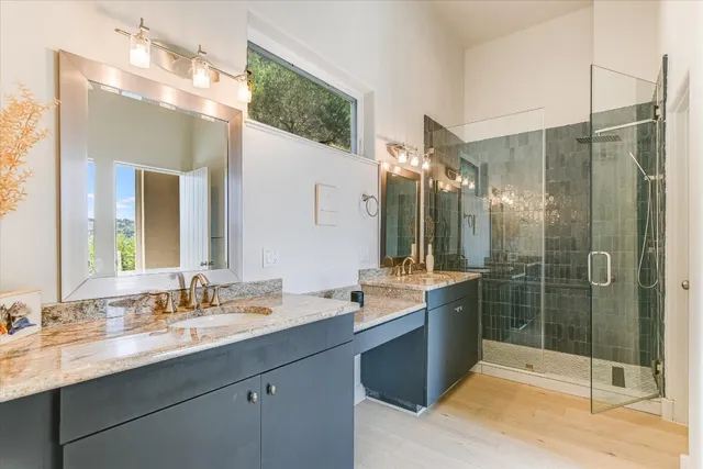 a bathroom with a double vanity sink mirror and shower