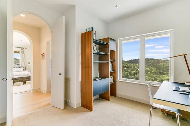 a view of a workspace with furniture and a window