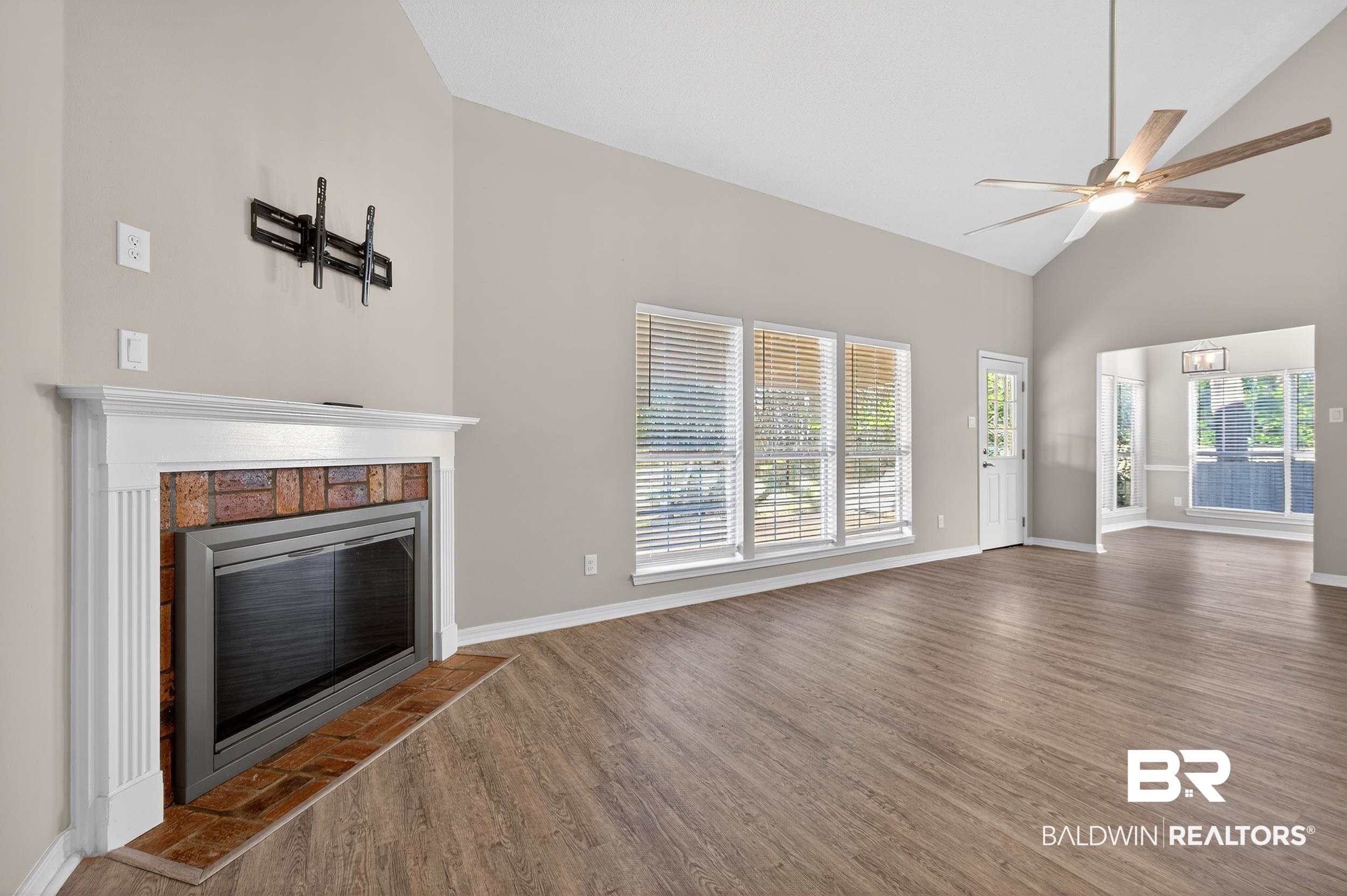 7050 Highpointe Place West Daphne, AL 36527 - Photo 26 of 66 Unfurnished living room with lofted ceiling, ceiling fan, dark wood finished floors, and a tiled fireplace