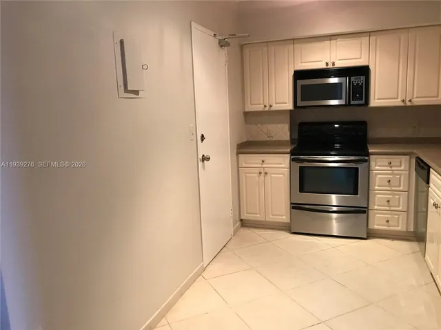 a kitchen with a refrigerator and cabinets