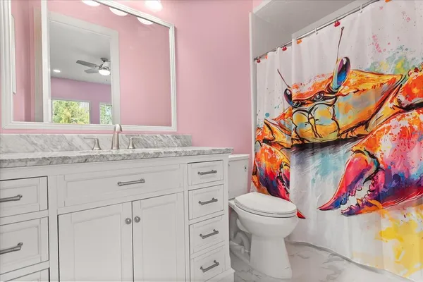 a bathroom with a granite countertop toilet sink and mirror