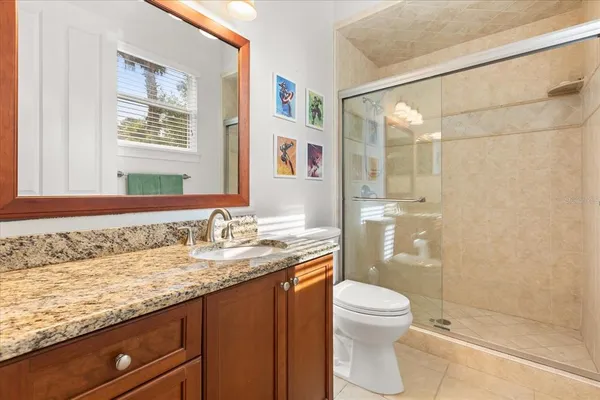 a bathroom with a granite countertop sink toilet and shower